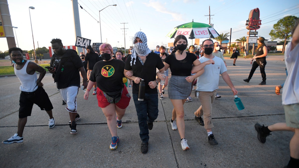 Protesters march down demanding justice for Trayford Pellerin on Saturday in Lafayette, La.