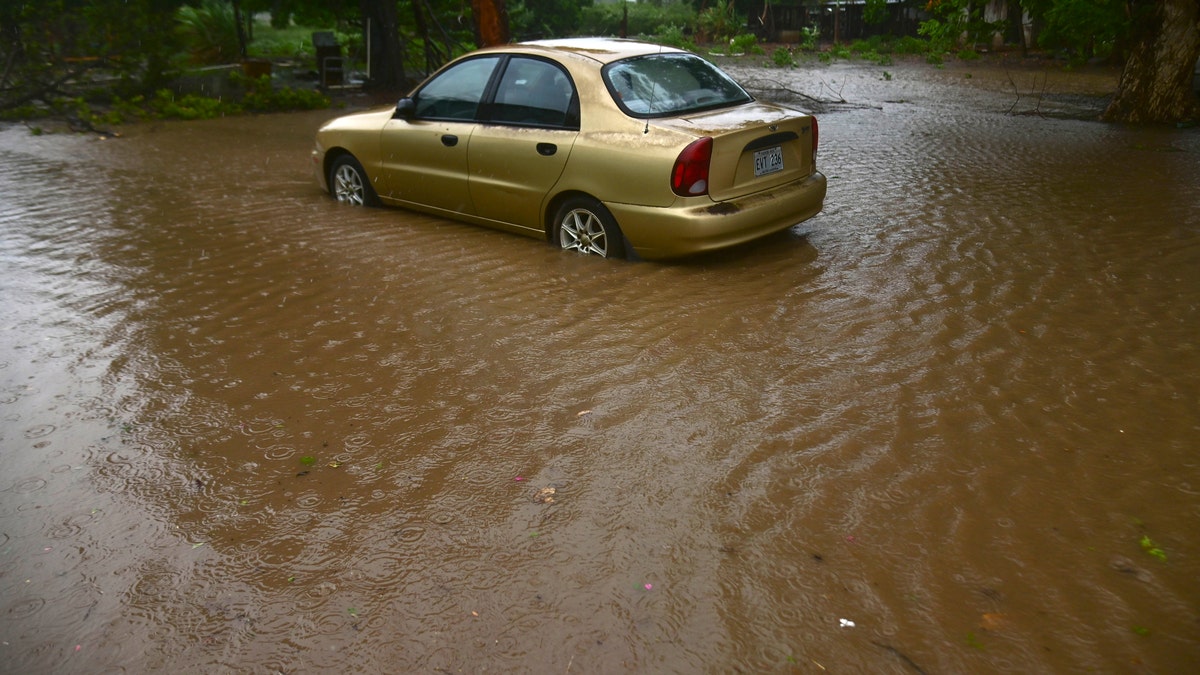 A car sits in flood waters caused by Tropical Storm Laura in Salinas, Puerto Rico, Saturday, Aug. 22, 2020. Laura began flinging rain across Puerto Rico and the Virgin Islands on Saturday morning and was expected to drench the Dominican Republic, Haiti and parts of Cuba during the day on its westward course.