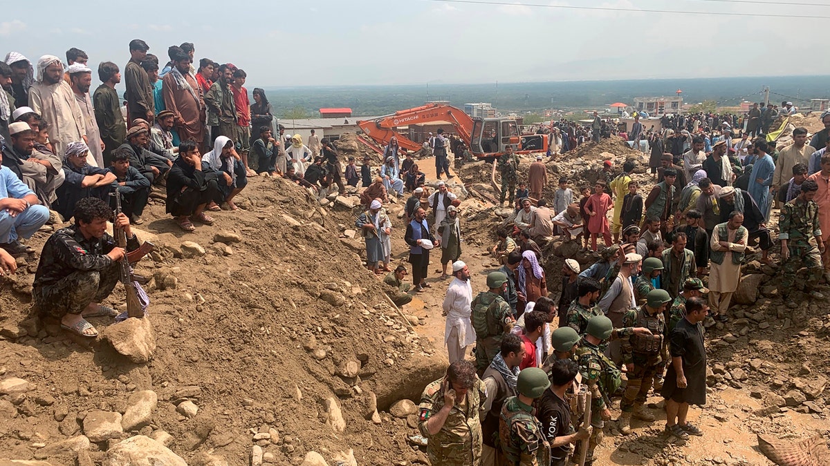 Soldiers and locals search for victims in a mudslide following heavy flooding in the Parwan province, north of Kabul, Afghanistan, Wednesday, Aug. 26, 2020.