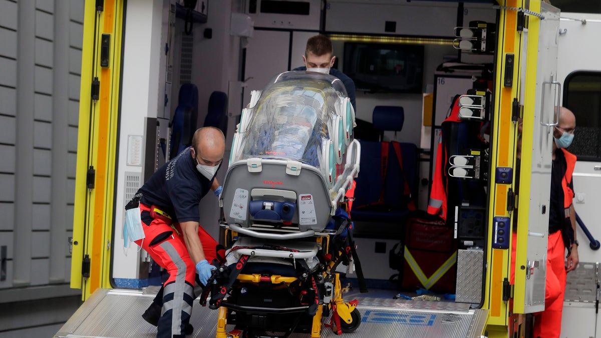 An empty stretcher is carried back into an ambulance that is believed to have transported Alexei Navalny at the emergency entrance of the Charite hospital in Berlin, Germany, on Saturday. (AP)