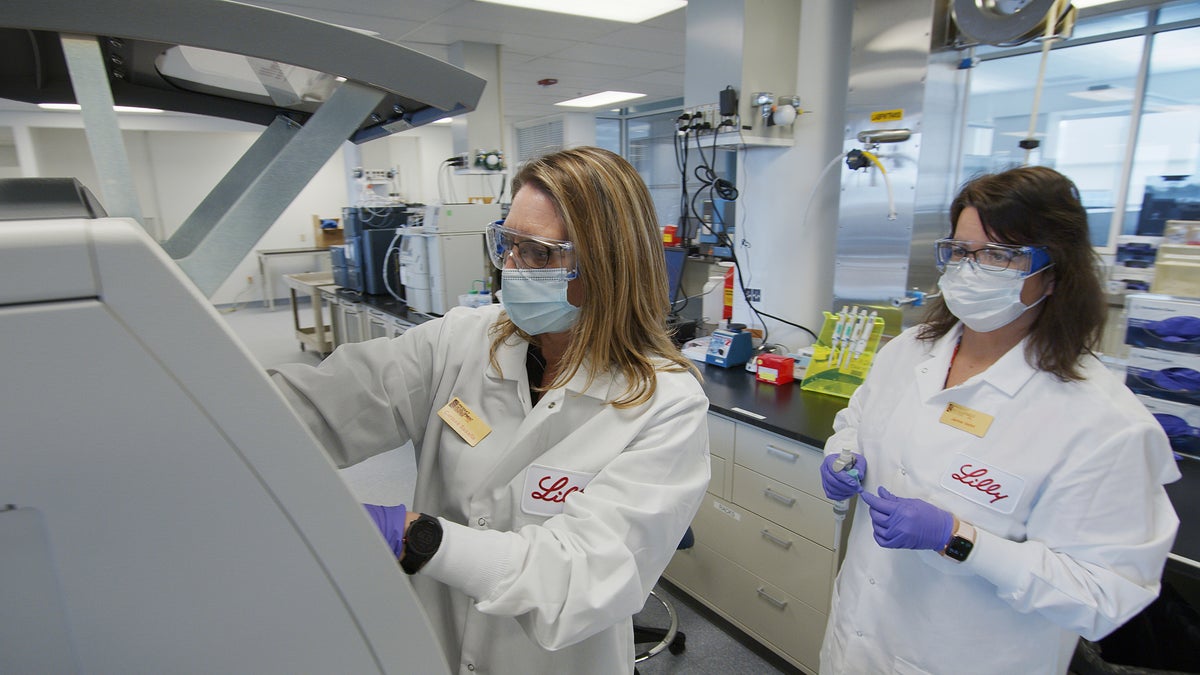 In this May 2020 photo provided by Eli Lilly, researchers prepare cells to produce possible COVID-19 antibodies for testing in a laboratory in Indianapolis. Antibodies are proteins the body makes when an infection occurs; they attach to a virus and help it be eliminated.