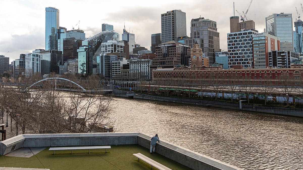 A lone man looks out toward the Yarra River and the empty Central Business District during lockdown in Melbourne, the captial city of Victoria state in Australia, on Aug. 5. Victoria state is considered a COVID-19 hotspot and has taken strict measures to prevent the spread of the virus. (AP Photo/Asanka Brendon Ratnayake)