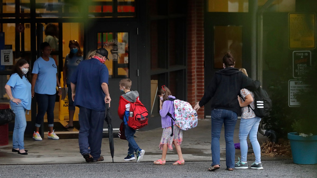 Students arrive to Dallas Elementary School for the first day of school amid the coronavirus outbreak on Monday, Aug. 3, 2020, in Dallas, Ga. (AP Photo/Brynn Anderson)