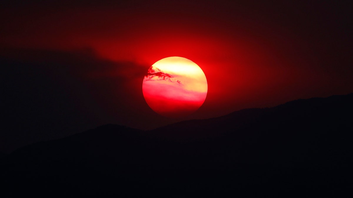 As wildfires burn throughout the Western Slope, the sun sets a bright orange behind the Rocky Mountains for residents of the eastern plains Wednesday, Aug. 12, 2020, in Denver.