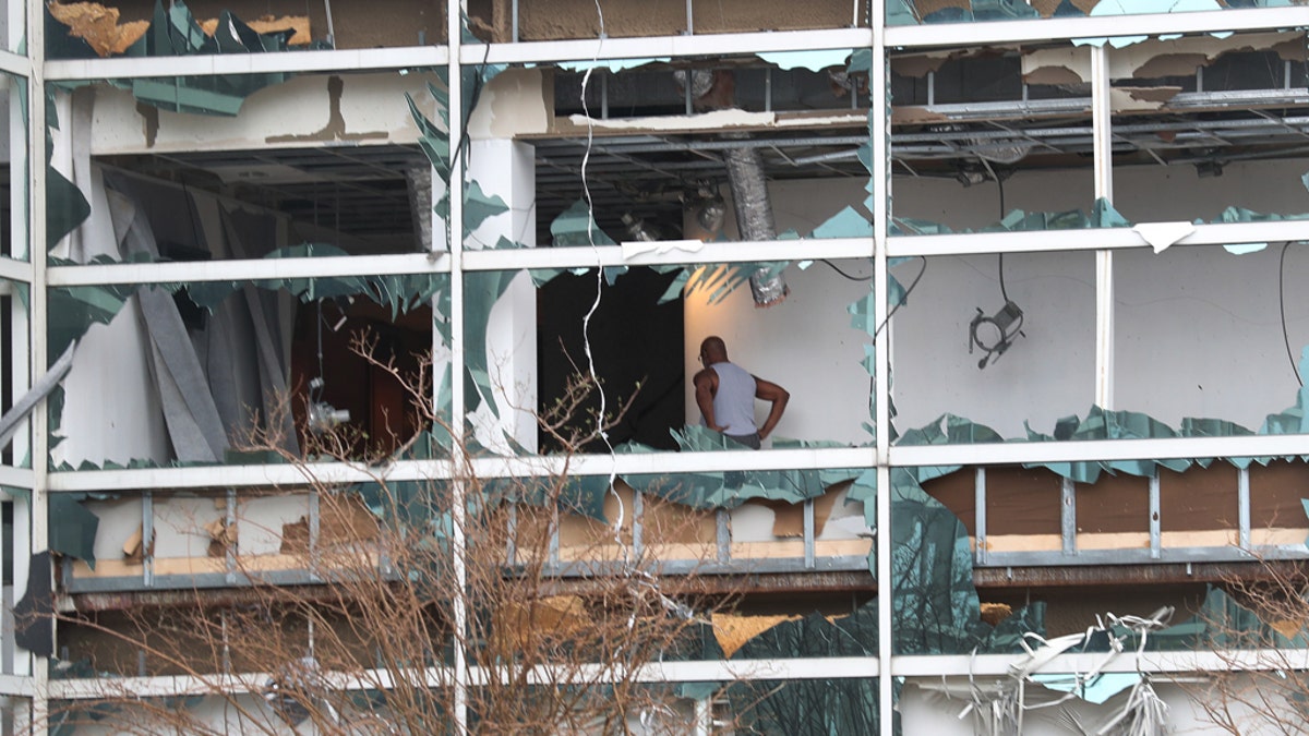 A person is seen walking through a building with its windows blown out in the downtown area after Hurricane Laura passed through on August 27, 2020 in Lake Charles, Louisiana.