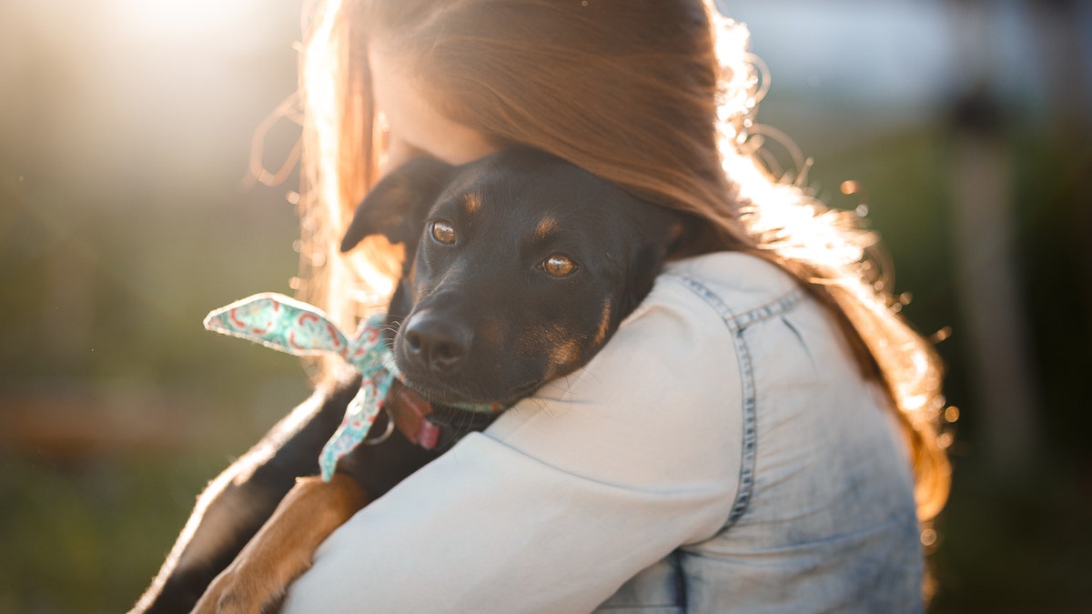 menina abraçando cachorro