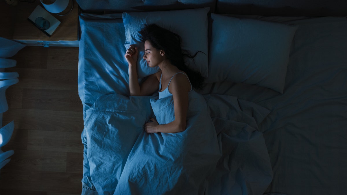 Woman sleeping in her bedroom at night.