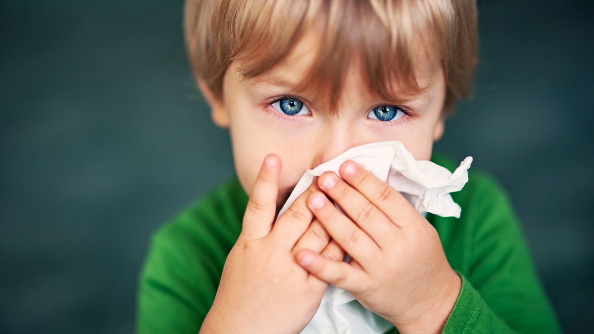 child blowing nose