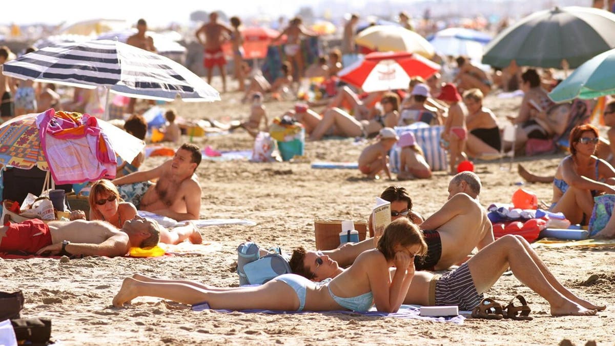 Beachgoers sunbathe at Cap d'Agde, France along the Mediterranean Sea.
