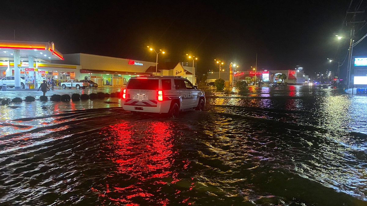 A car is driven along water-covered Sea Mountain Highway in North Myrtle Beach, S.C., as Isaias neared the Carolinas on Monday night, Aug. 3, 2020.