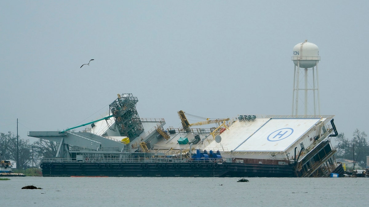 Water surrounds a damaged barge Friday, Aug. 28, 2020, in Cameron, La., after Hurricane Laura moved through the area Thursday.