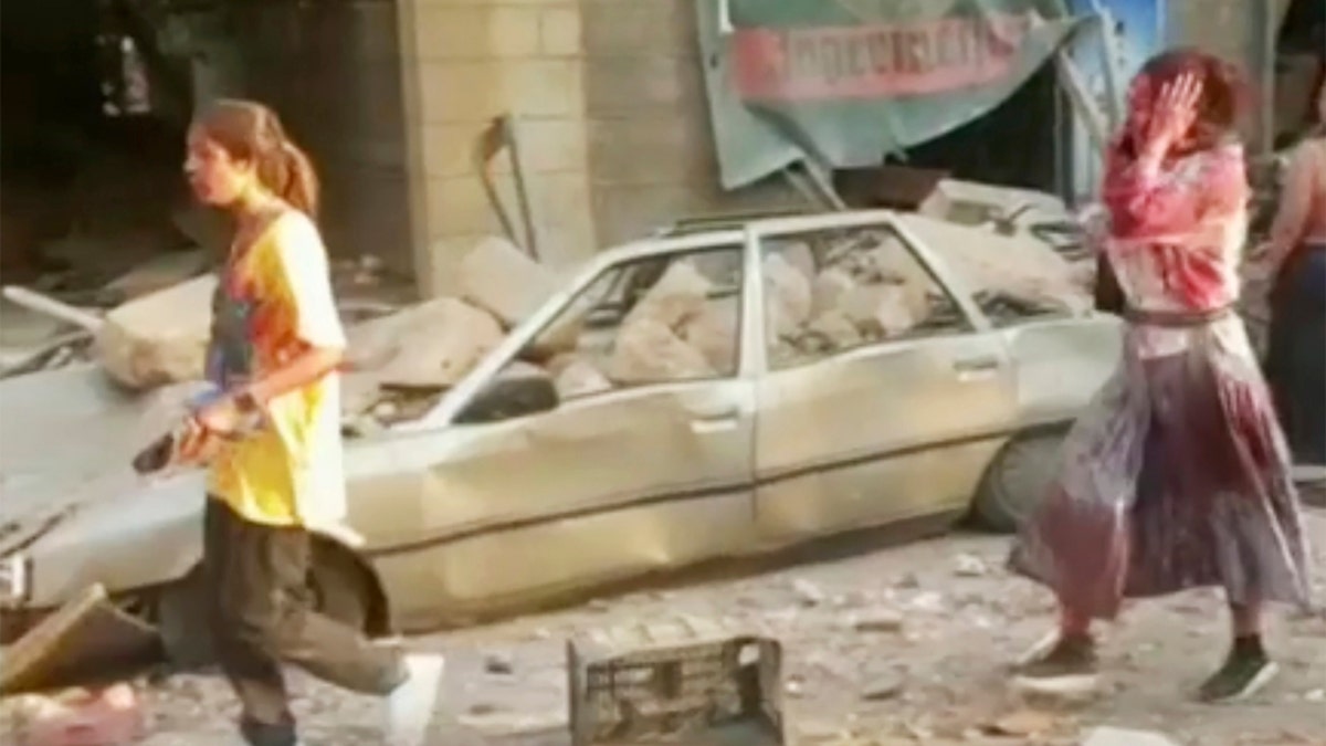 In this frame from video, people walk down the street after an explosion in Beirut, Aug. 4.