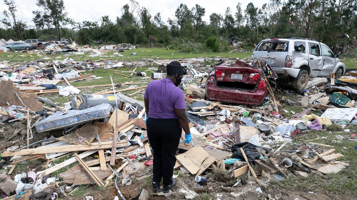 Cynthia Cooper looks for personal items for a family member who had their home destroyed after a tornado spawned by Hurricane Isaias destroyed a rural mobile home neighborhood killing two residents near Windsor N.C. on Wednesday, Aug. 5, 2020.