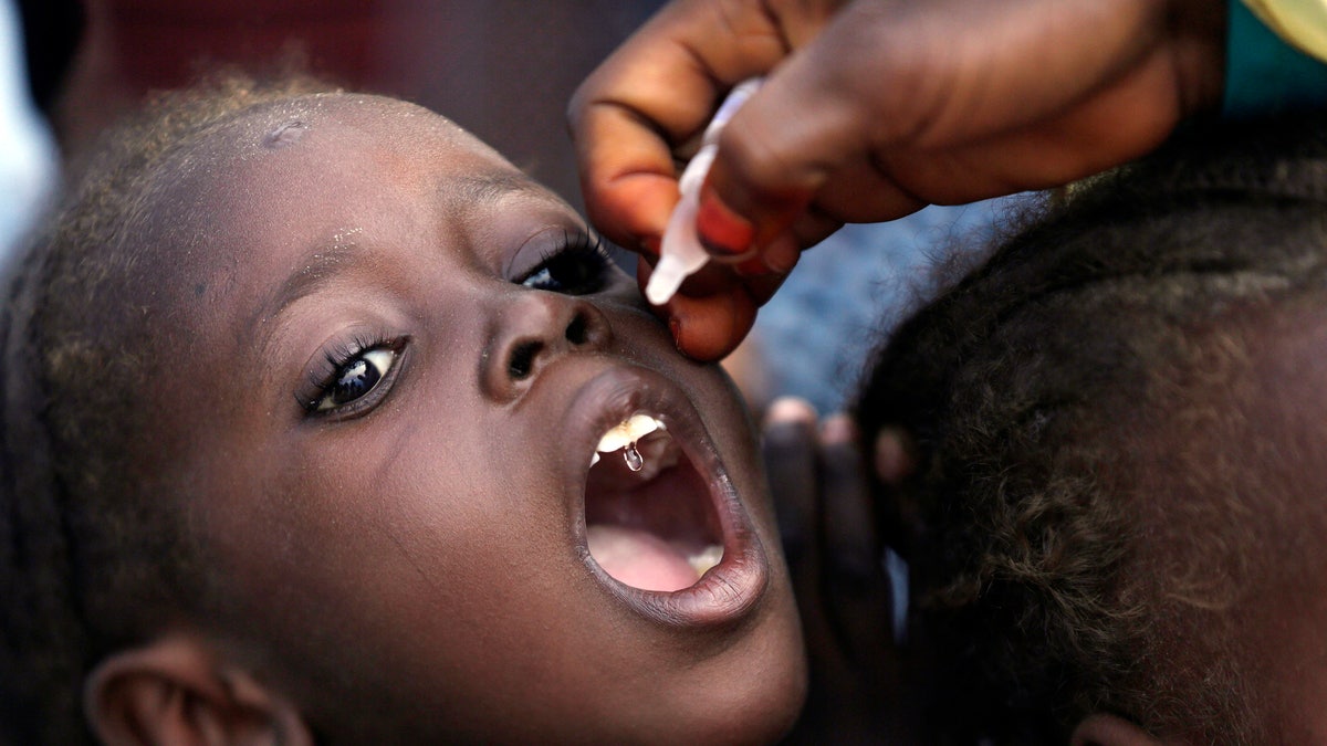 In this Sunday, Aug. 28, 2016, file photo, a health official administers a polio vaccine to a child at a camp for people displaced by Islamist Extremists in Maiduguri, Nigeria. Health authorities on Tuesday, Aug. 25, 2020, are expected to declare the African continent free of the wild poliovirus after decades of effort, though cases of vaccine-derived polio are still sparking outbreaks of the paralyzing disease in more than a dozen countries.
