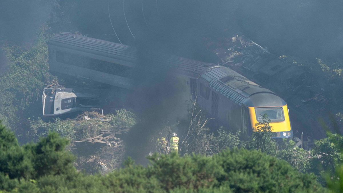 Emergency services personnel are seen at the scene of a train crash near Stonehaven in northeast Scotland on August 12, 2020. (Photo by Michal Wachucik / AFP via Getty Images)