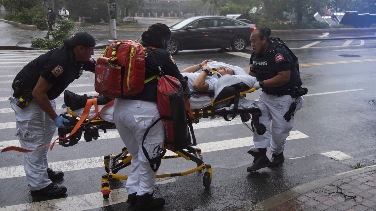 A person who was injured while trying to secure barriers meant to block flood waters at a building at Water and State Streets in lower Manhattan is transported after being injured Tuesday, Aug. 4, 2020, in New York.
