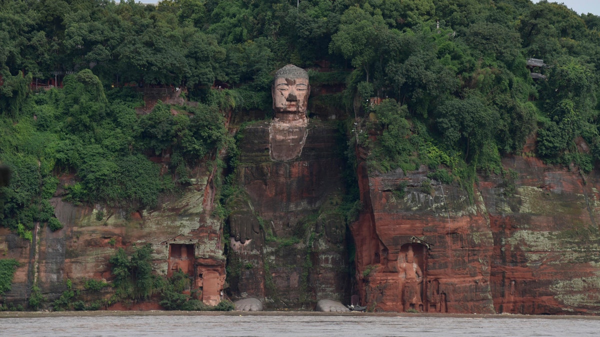 In this photo released by China's Xinhua News Agency, floodwaters flow near the historic Giant Buddha in Leshan in southwestern China's Sichuan Province on Aug. 18, 2020.