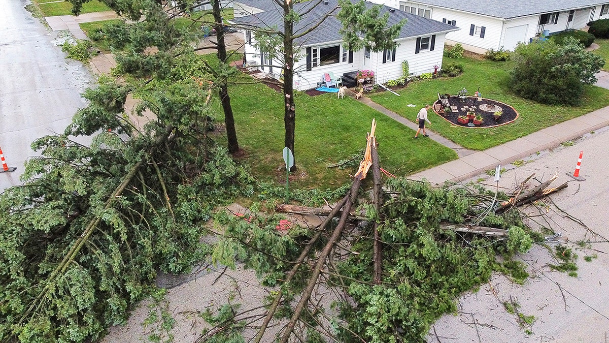 Downed trees and a utility pole in front of the home of Tim and Patricia Terres in Walcott, Iowa after high winds and heavy rain passed through the area Monday, Aug. 10, 2020, in Davenport, Iowa.