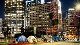 Los Angeles, CA, USA - September 2018: View of homeless people tents near the highway in LA Downtown with skyscrapers.