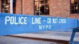 Police line, do not cross sign against a brick wall with windows in New York