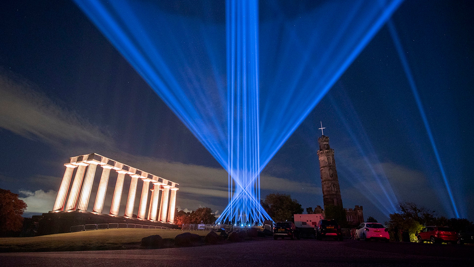 The sky above Calton Hill is lit up by My Light Shines On, an outdoor light installation for the 2020 Edinburgh International Festival, Aug. 7.