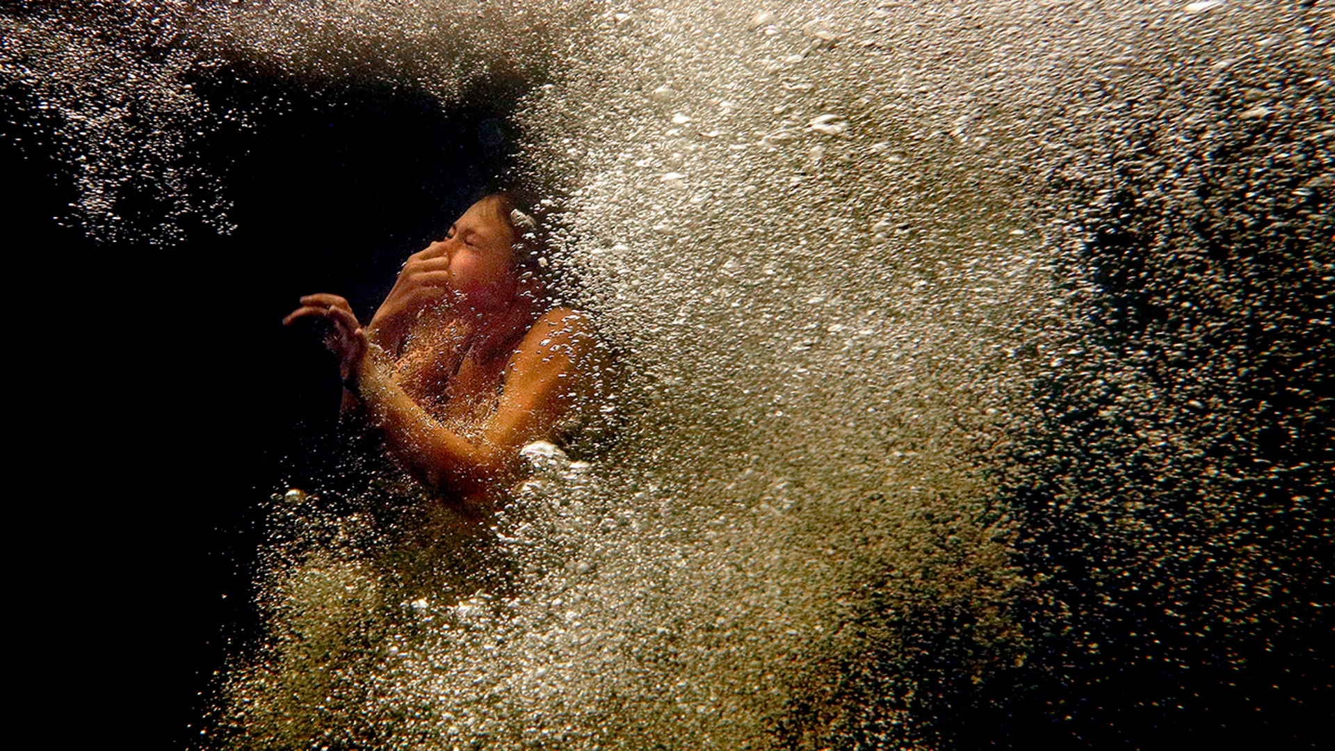 Marley Wentworth, of Newfield, Maine, surfaces through bubbles after jumping into the Mousam River at Indian's Last Leap, a popular swimming hole in Springvale, Maine, Aug. 11, 2020.