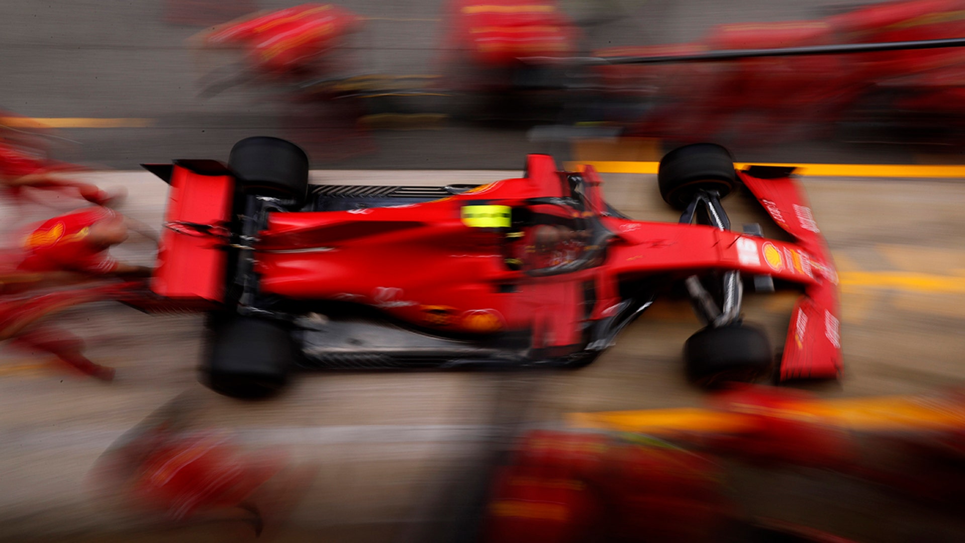 Mechanics practice a tire change on Charles Leclerc's Ferrari during preparations ahead of the Formula One Grand Prix at the Barcelona Catalunya racetrack in Montmelo, Spain, Aug. 13, 2020.
