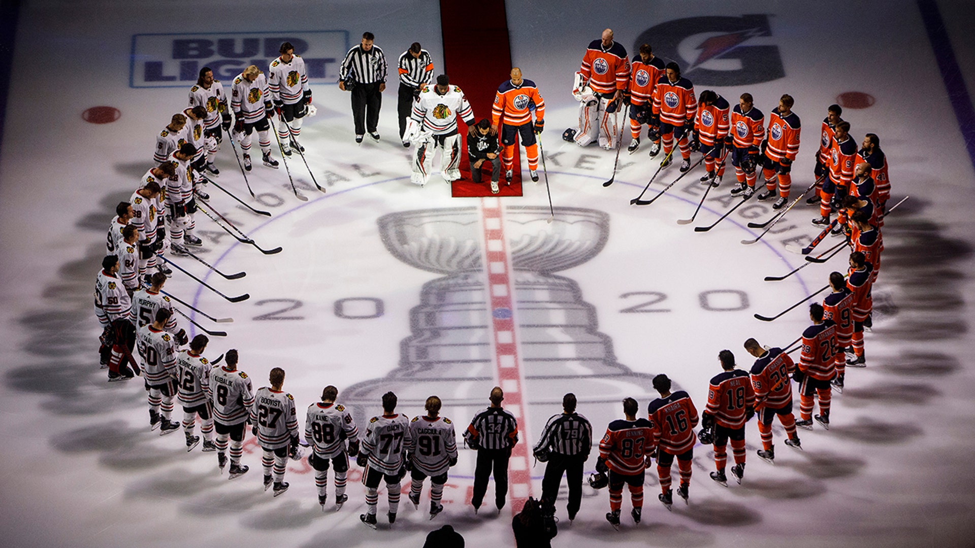 Minnesota Wild's Matt Dumba takes a knee during the national anthem flanked by Edmonton Oilers' Darnell Nurse and Chicago Blackhawks' Malcolm Subban before an NHL hockey game in Edmonton, Alberta, Aug. 1, 2020.