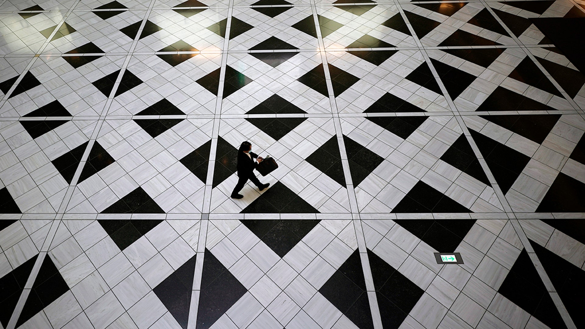 A man wearing a face mask to help curb the spread of the coronavirus walks through a building in Tokyo, Aug. 27, 2020. 