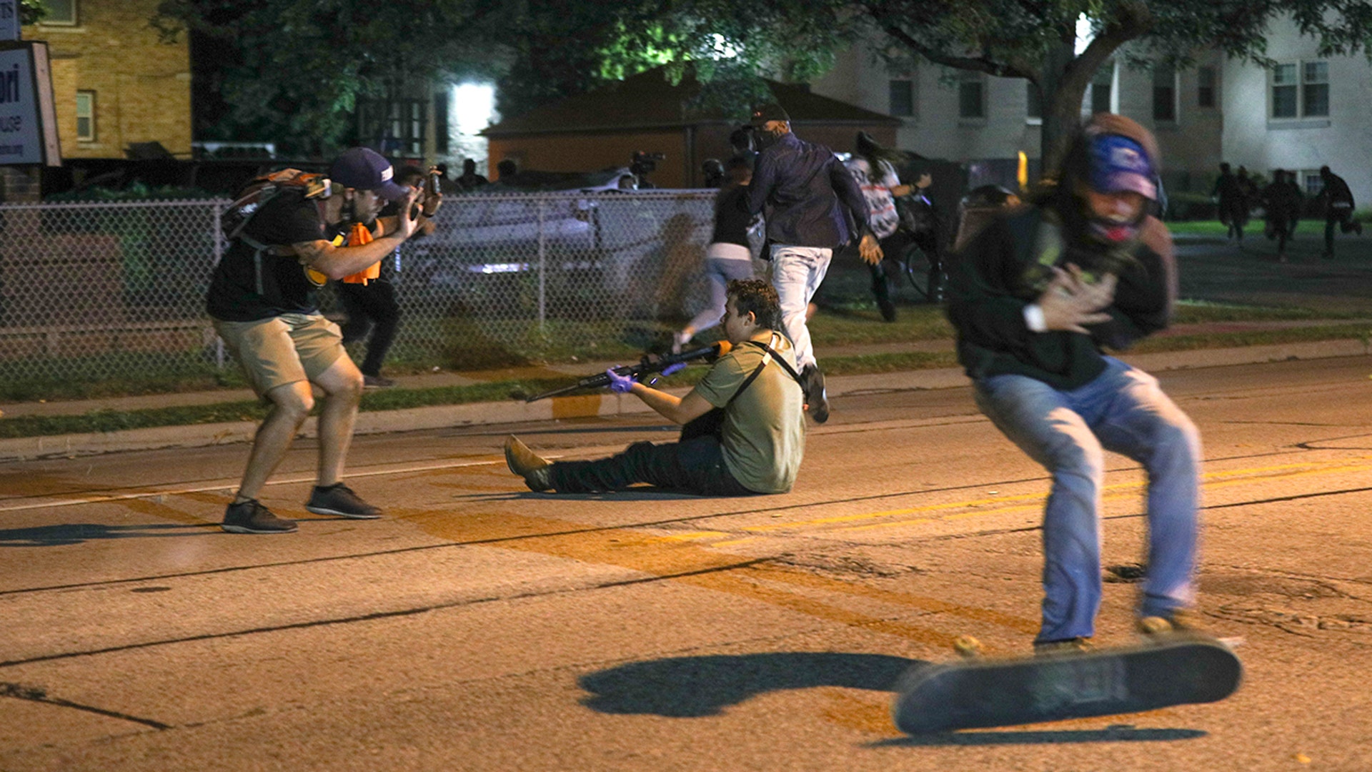 A man grabs his chest after being shot during clashes between protesters and armed civilians over the shooting of Jacob Blake by a police officer in Kenosha, Wis., Aug. 25, 2020. 