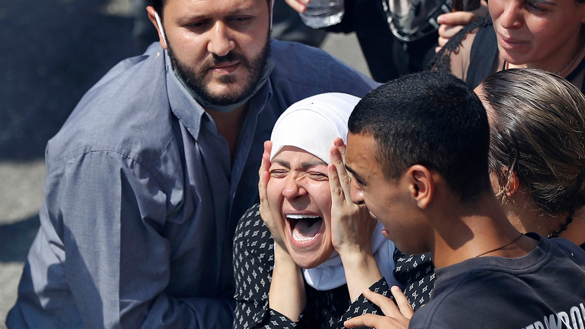 The wife of Rami Kaaki, one of ten firefighters who were killed during the last week's explosion that hit the seaport of Beirut, mourns during her husband's funeral at the firefighter headquarters, in Beirut, Lebanon, Aug. 11, 2020.