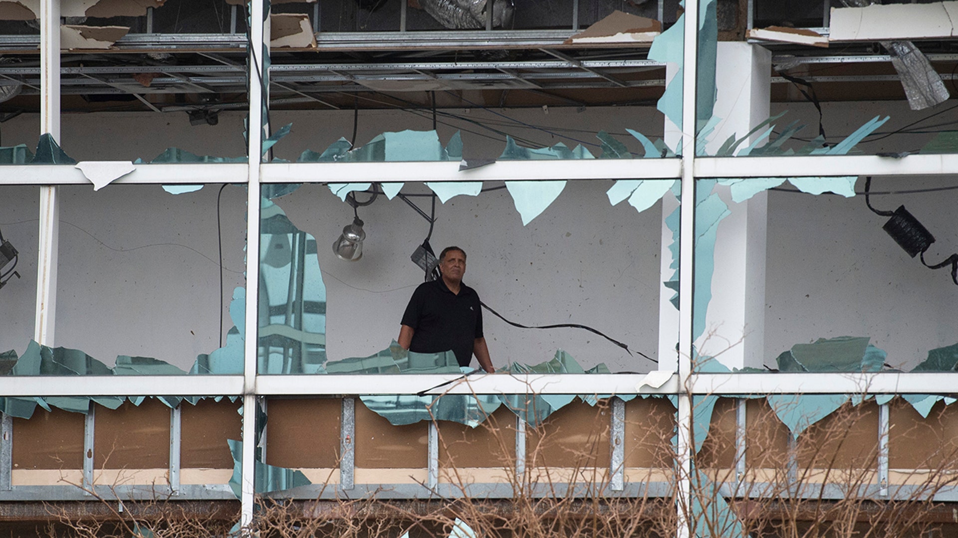 A man looks at the damage inside the Capitol One Bank Tower after having its windows blown out by Hurricane Laura in Lake Charles, La., Aug. 27, 2020. 