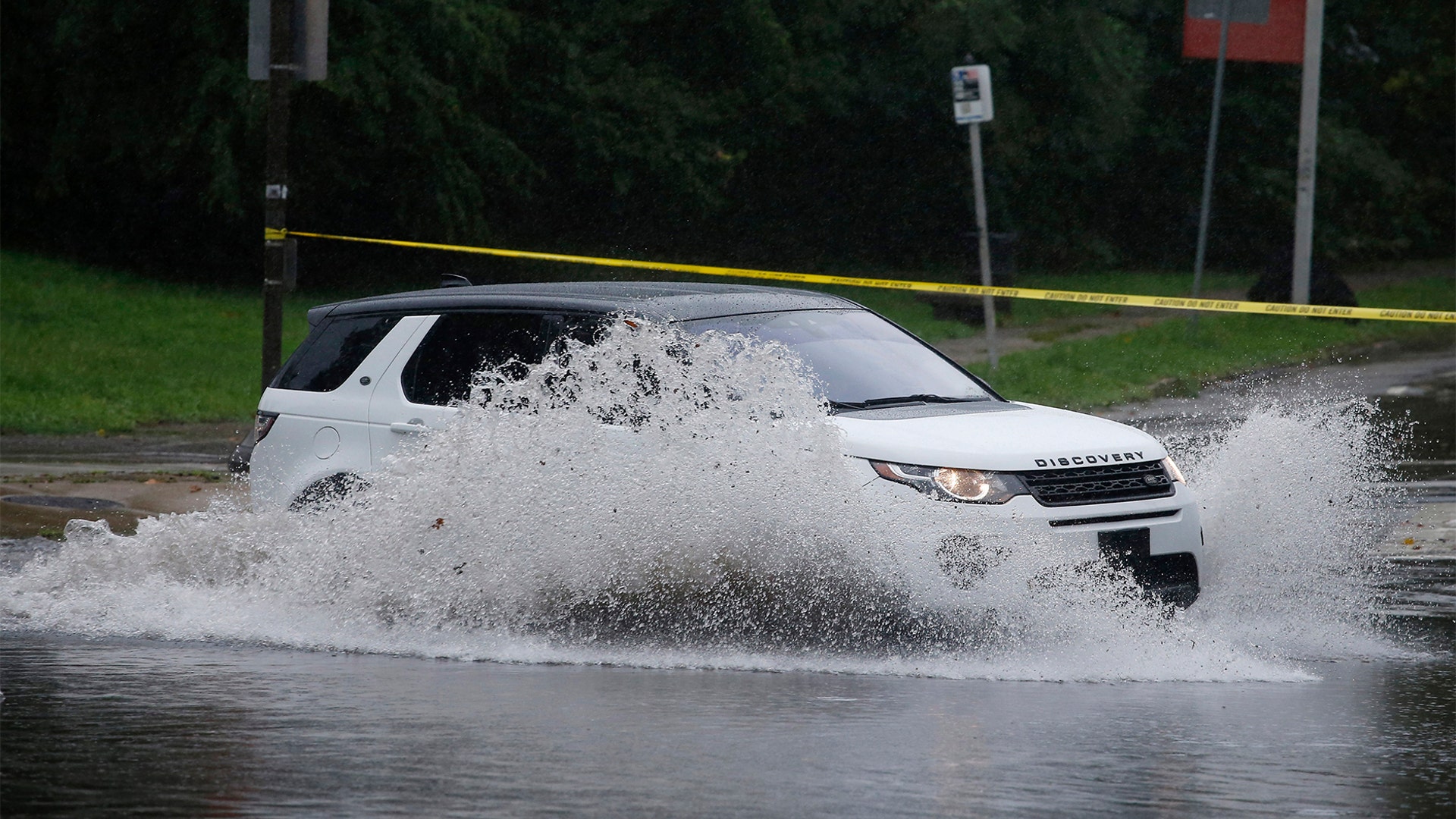 A motorist drives through a flooded intersection during Tropical Storm Isaias, Tuesday, Aug. 4, 2020, in Philadelphia.