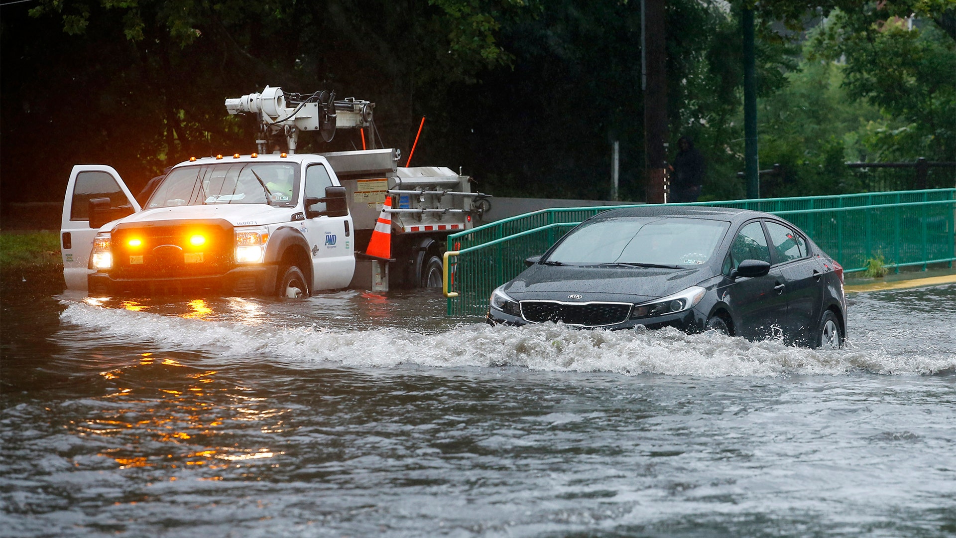 A motorist drives through a flooded intersection during Tropical Storm Isaias, Tuesday, Aug. 4, 2020, in Philadelphia. 