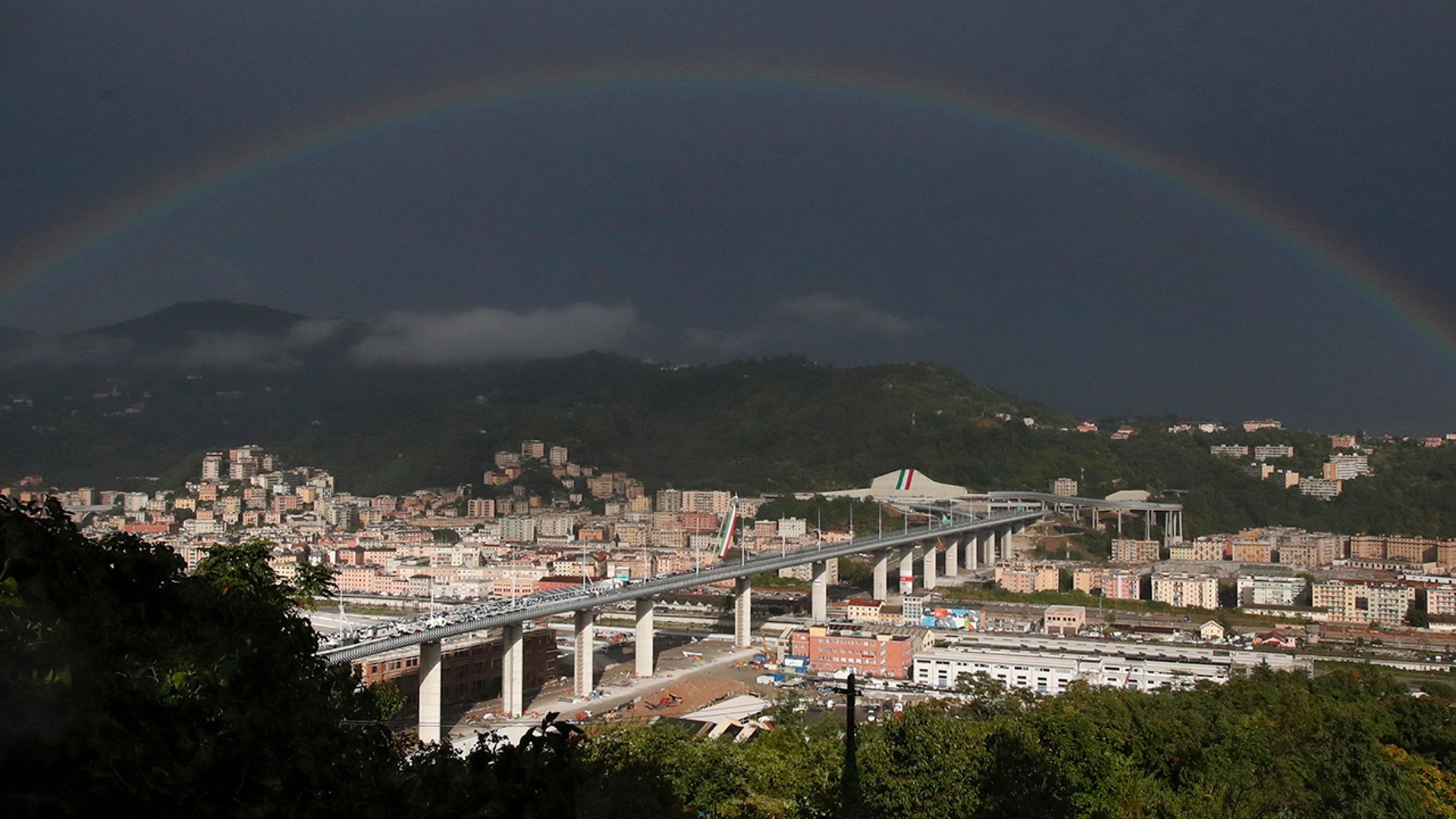 A rainbow shines over the new San Giorgio Bridge in Genoa, Italy, Aug. 3, 2020. 