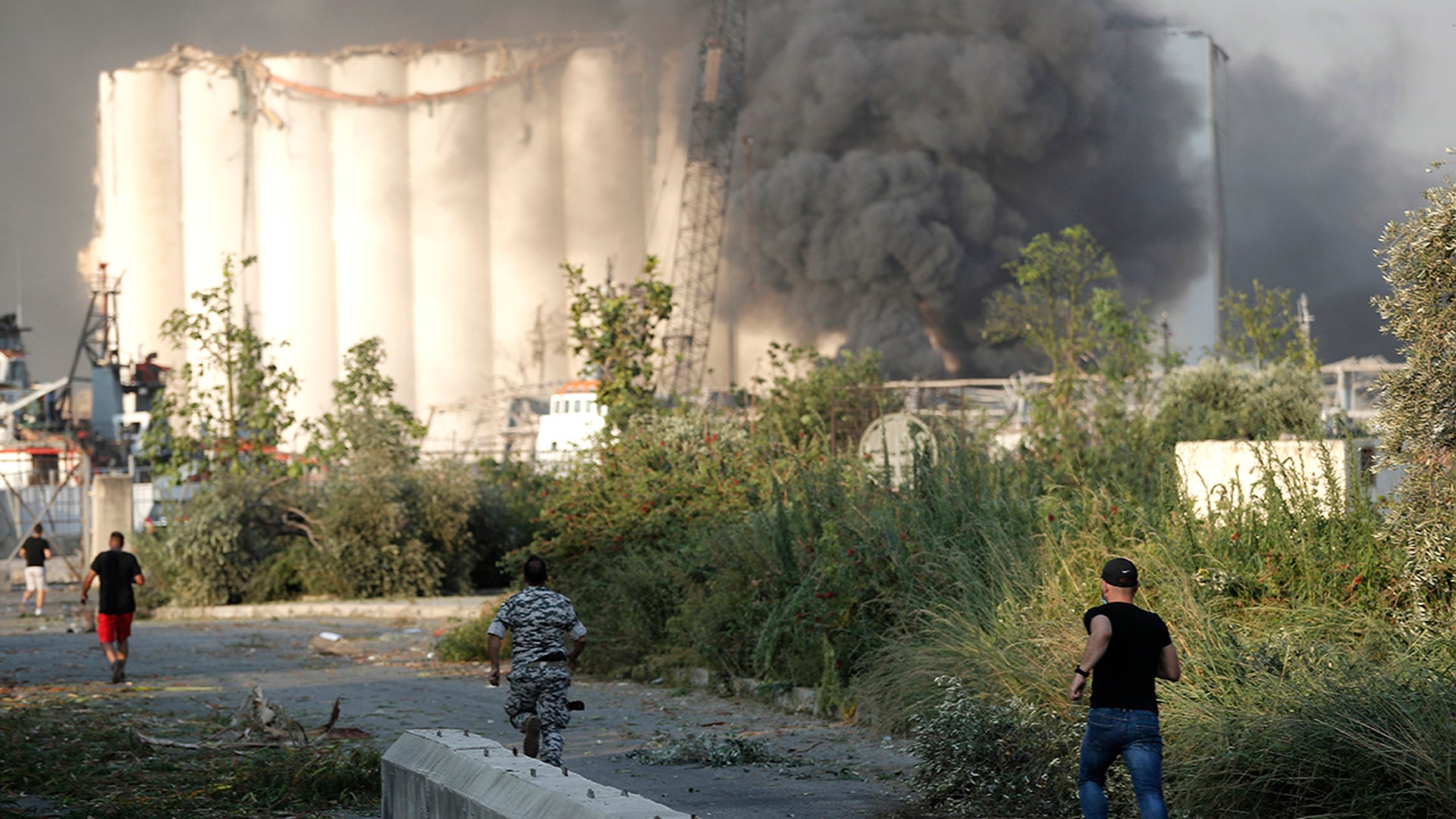 Lebanese security officers run to the explosion scene that hit the seaport, in Beirut, Lebanon, Tuesday, Aug. 4, 2020. 