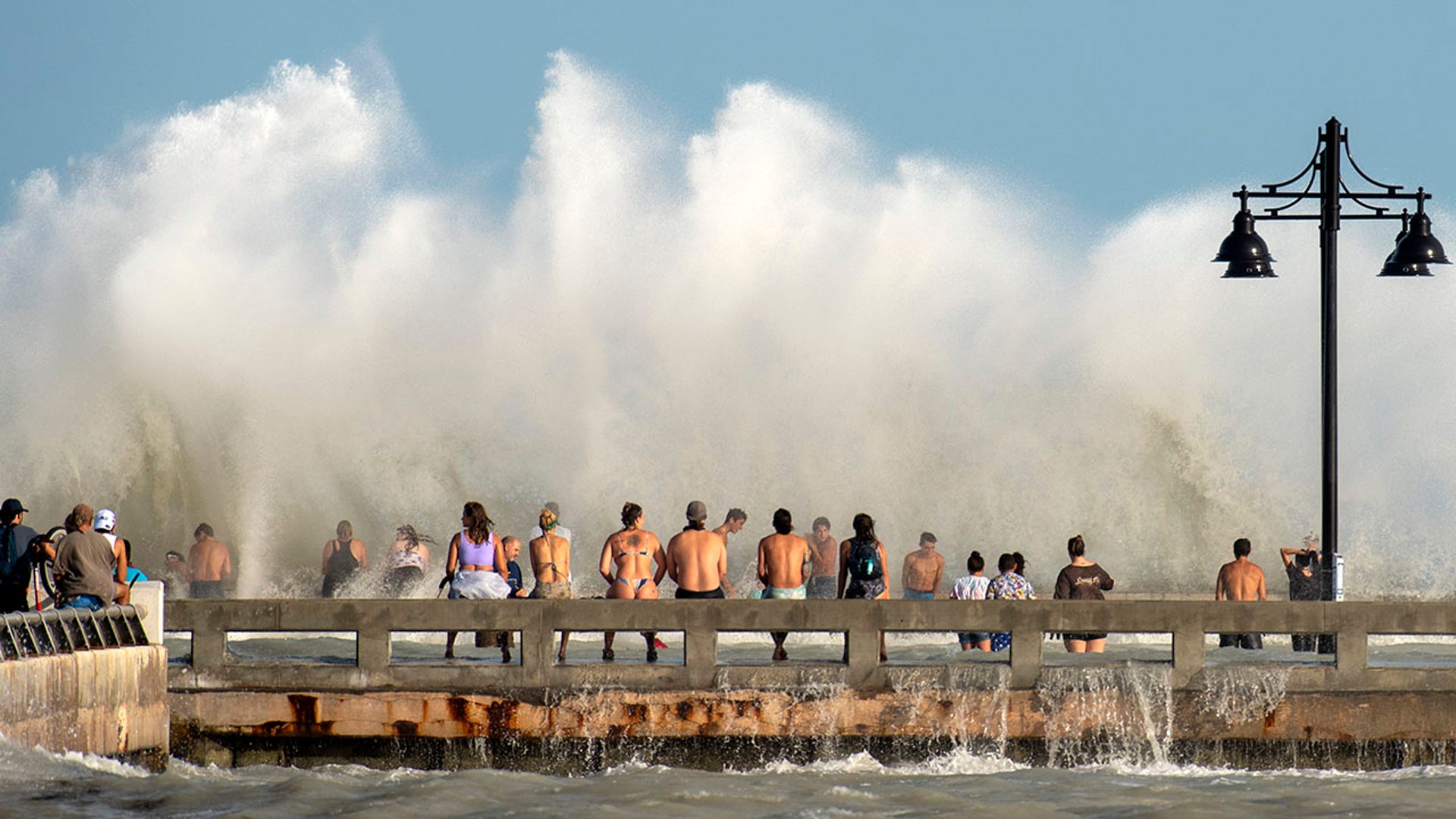 Curious residents of Key West, Fla., flock to the Edward B. Knight Pier Monday, Aug. 24, 2020, to witness the wind and wave action of Hurricane Laura as the storm passes well to the west of the Florida Keys. (Rob O'Neal/The Key West Citizen via AP)