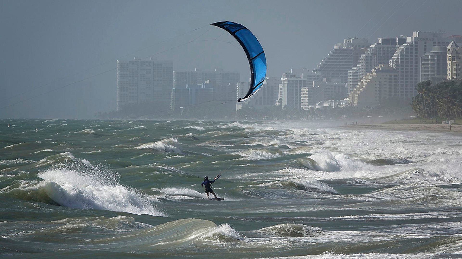 A kite surfer enjoys the wind in Lauderdale, Fla., Monday, Aug. 24, 2020. Tropical Storm Marco began falling apart Monday, easing one threat to the Gulf Coast but setting the stage for the arrival of Laura as a potentially supercharged Category 3 hurricane with winds topping 110 mph (177 kph). (Joe Cavaretta/South Florida Sun-Sentinel via AP)