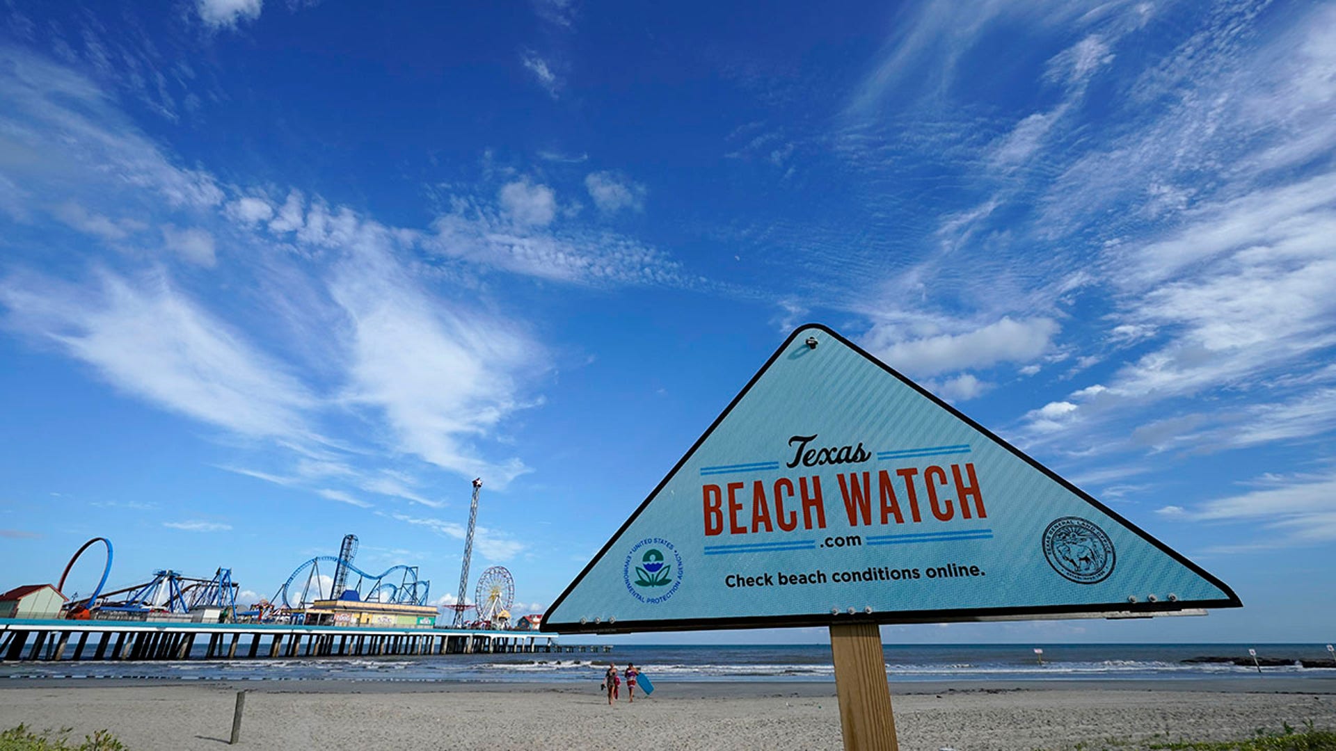 Beachgoers leave the beach Tuesday, Aug. 25, 2020, in Galveston, Texas, as Hurricane Laura heads toward the Gulf Coast. (AP Photo/David J. Phillip)