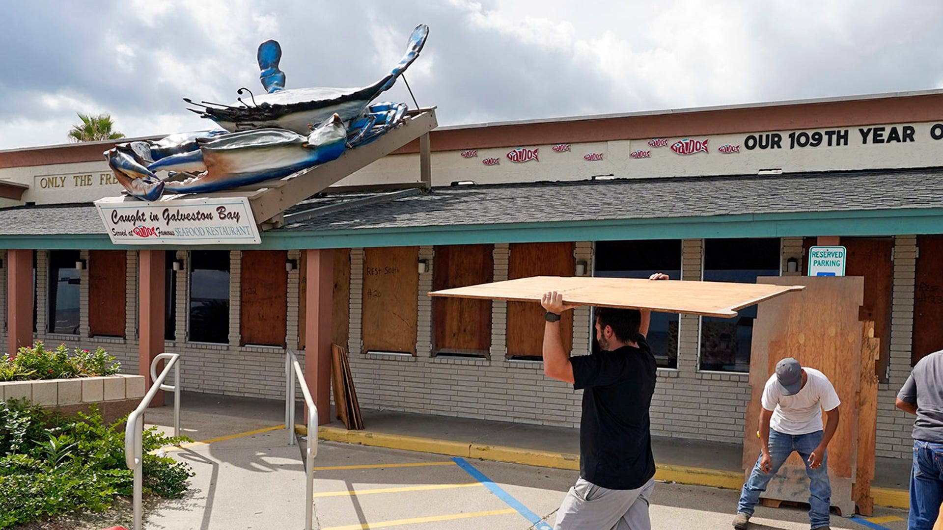 Owner Nick Gaido, left, helps board up windows at his Gaido's Seafood Restaurant Tuesday, Aug. 25, 2020, in Galveston, Texas, as Hurricane Laura heads toward the Gulf Coast. (AP Photo/David J. Phillip)