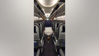 Flight attendant flips upside-down, closes overhead compartment with her heels in viral video