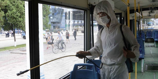A man in a protective suit disinfects the inside of a wheelchair bus to help curb the spread of coronavirus in Pyongyang, North Korea, on Thursday, August 13, 2020. (AP Photo / Jon Chol Jin)