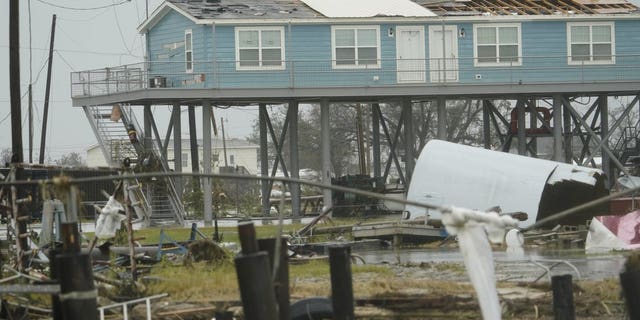 Flooding surrounds damaged homes Friday, Aug. 28, 2020, in Cameron, La., after Hurricane Laura moved through the area Thursday. (AP Photo/David J. Phillip)