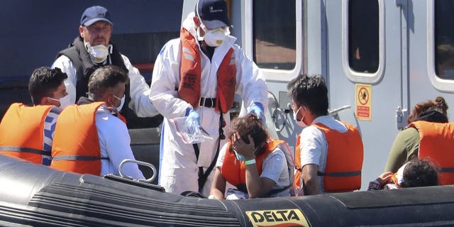A Border Force vessel brings a group of people thought to be migrants into the port city of Dover, England, from small boats, Friday Aug. 7, 2020. The British government says it will strengthen border measures as calm summer weather has prompted a record number of people to attempt the risky sea crossing in small vessels, from northern France to England.