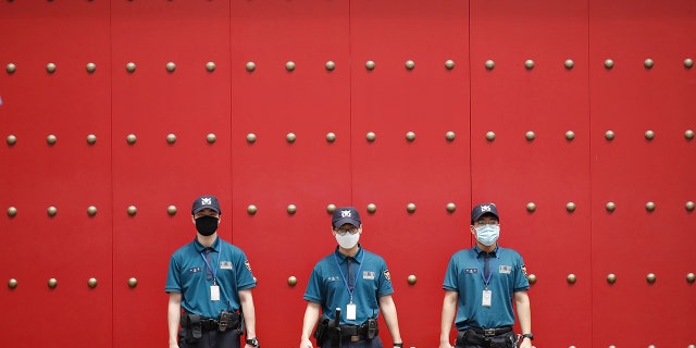 Police officers wearing face masks to help protect against the spread of the new coronavirus, stand guard in downtown Seoul, South Korea, Tuesday, Aug. 4, 2020. (AP Photo/Lee Jin-man)