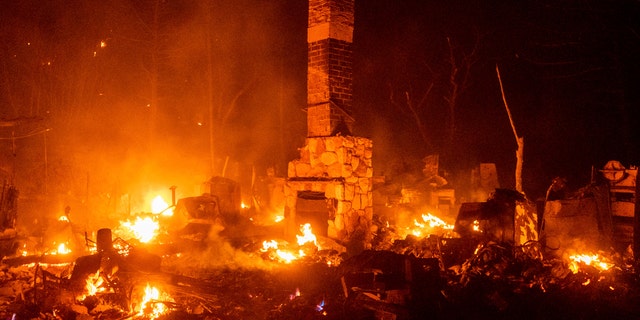 A chimney stands among the smoldering remains of a residence as the Lake Fire burns in the Angeles National Forest, Calif., north of Santa Clarita on Thursday, Aug. 13, 2020.