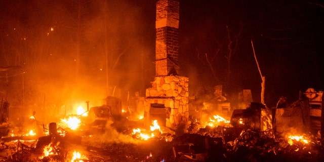 A chimney stands among the smoldering remains of a residence as the Lake Fire burns in the Angeles National Forest, Calif., north of Santa Clarita on Thursday, Aug. 13, 2020.