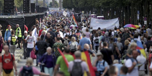 People attend a protest rally in Berlin, Germany, Saturday, Aug. 29, 2020 against new coronavirus restrictions in Germany. Police in Berlin have requested thousands of reinforcements from other parts of Germany to cope with planned protests at the weekend by people opposed to coronavirus restrictions. (AP Photo/Michael Sohn)