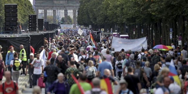 People attend a protest rally in Berlin, Germany, Saturday, Aug. 29, 2020 against new coronavirus restrictions in Germany. Police in Berlin have requested thousands of reinforcements from other parts of Germany to cope with planned protests at the weekend by people opposed to coronavirus restrictions. (AP Photo/Michael Sohn)