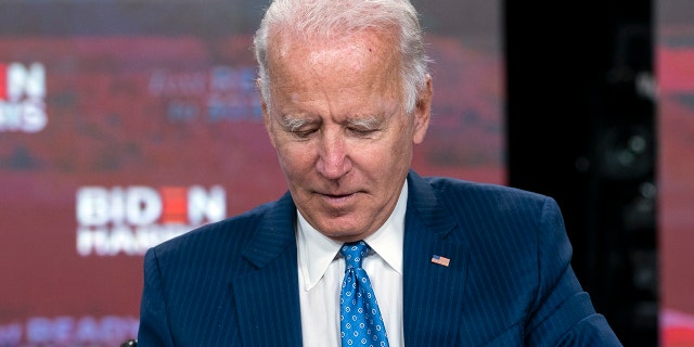 Democratic presidential candidate former Vice President Joe Biden signs a required document for receiving the Democratic nomination for President of the United States in Wilmington, Del., Friday, Aug. 14, 2020. (AP Photo/Carolyn Kaster)